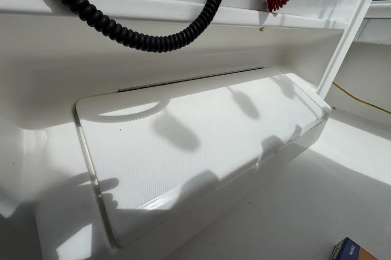 Slide: The Image of 2018 Regulator 34SS boat interior detail with storage compartment and coiled cable. - 83