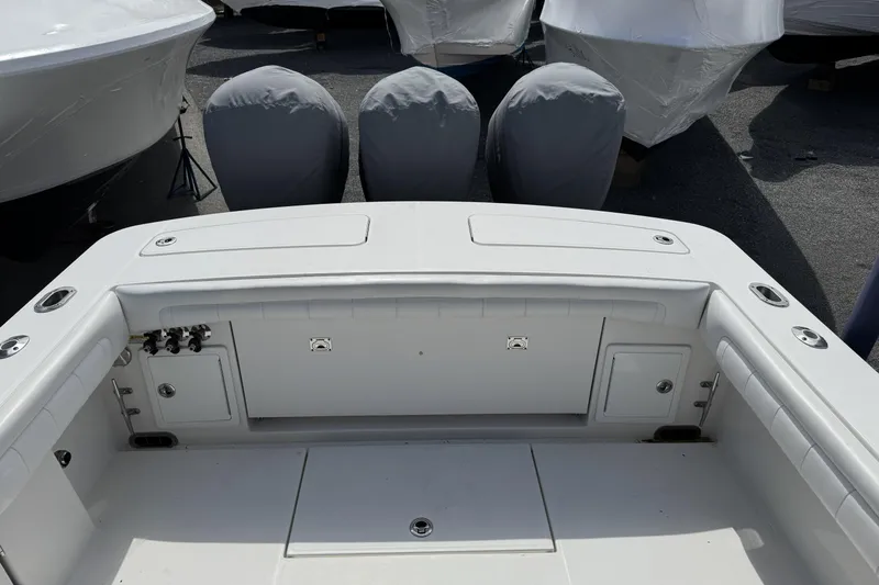 Slide: The Image of 2018 Regulator 34SS boat deck with covered engines in a marina. - 87