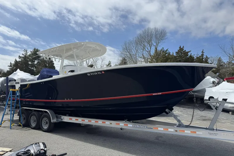 Slide: The Image of 2018 Regulator 34SS boat on trailer, parked outdoors under cloudy sky. - 95