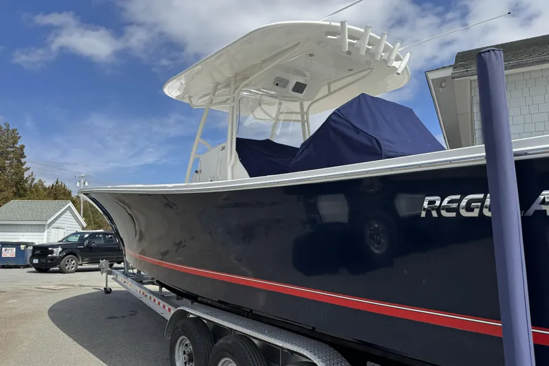 Slide: The Image of 2018 Regulator 34SS boat on trailer, featuring sleek design and navy blue hull. - 96