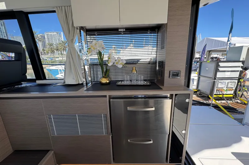 Slide: The Image of Interior of 2026 Jeanneau NC 1295 Coupe with modern kitchen and scenic marina view. - 10