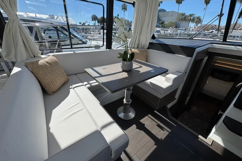Slide: The Image of Interior of 2026 Jeanneau NC 1295 Coupe with elegant seating and table arrangement. - 11