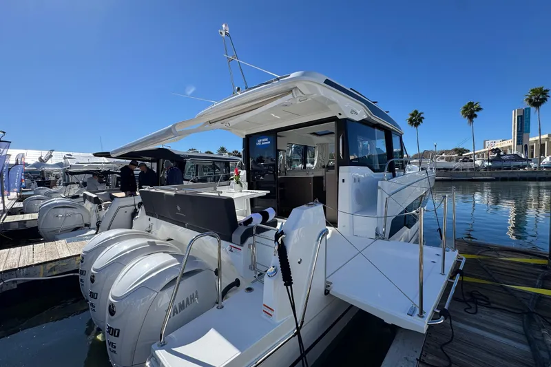 Slide: The Image of 2026 Jeanneau NC 1295 Coupe docked, featuring Yamaha engines, under clear blue sky. - 3