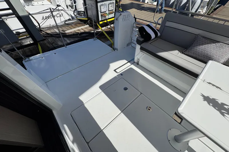 Slide: The Image of 2026 Jeanneau NC 1295 Coupe boat deck with seating and table, docked at marina. - 5