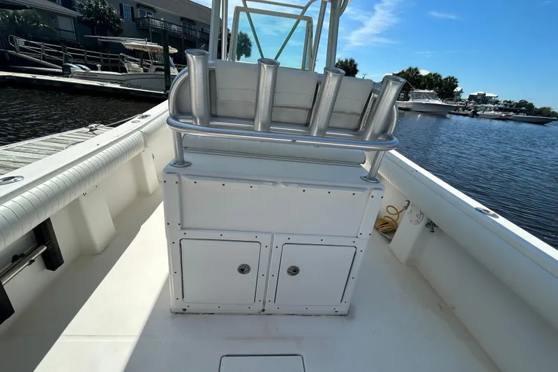 Slide: The Image of 2005 Regulator 26 Forward Seating boat interior with rod holders, docked by the water. - 10