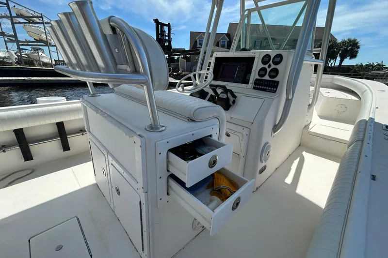 Slide: The Image of 2005 Regulator 26 Forward Seating boat interior with open storage drawers and control panel. - 13