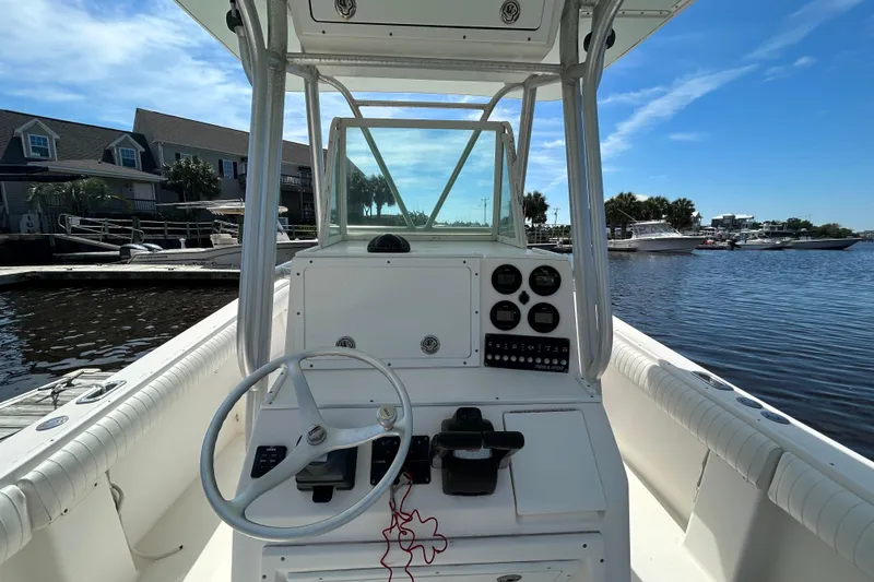 Slide: The Image of 2005 Regulator 26 Forward Seating boat at marina, clear sky, waterfront view. - 17