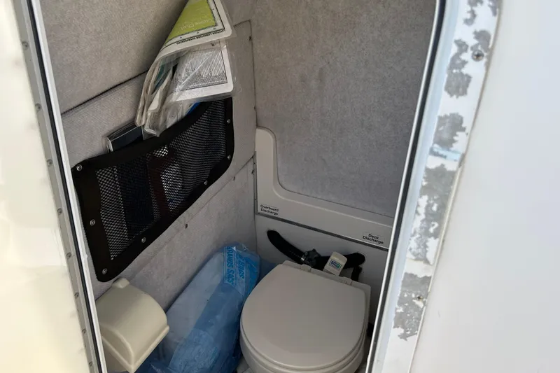 Slide: The Image of Interior of a 2005 Regulator 26 Forward Seating boat with a compact marine toilet. - 26
