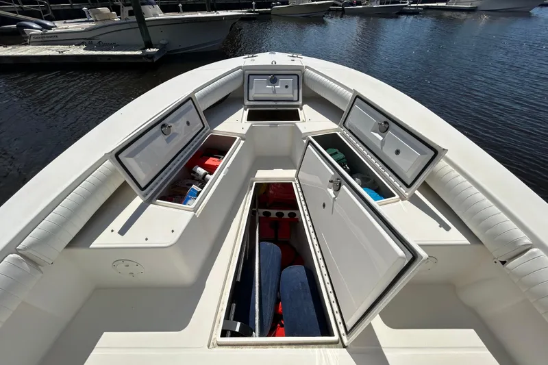 Slide: The Image of 2005 Regulator 26 Forward Seating boat with open storage compartments at the dock. - 29