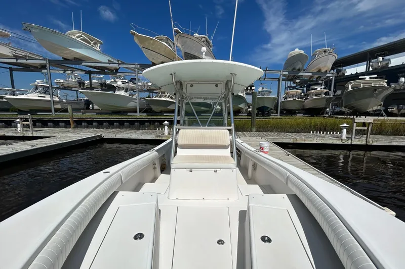Slide: The Image of 2005 Regulator 26 Forward Seating boat docked, surrounded by stacked boats under a clear blue sky. - 35