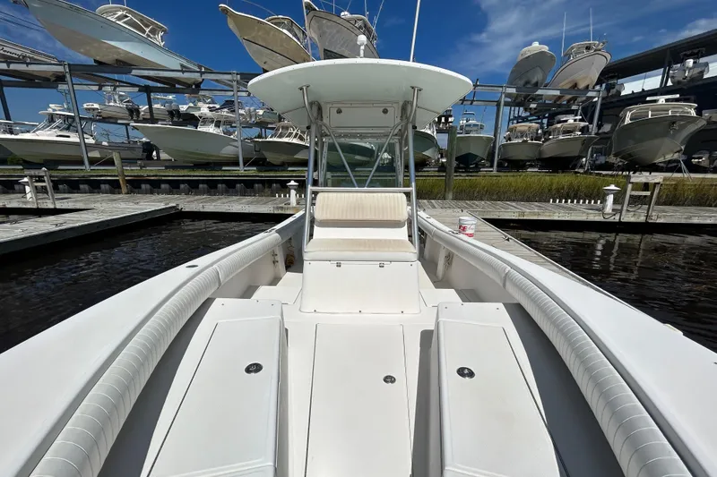 Slide: The Image of 2005 Regulator 26 Forward Seating boat docked, surrounded by stacked boats under a clear sky. - 36