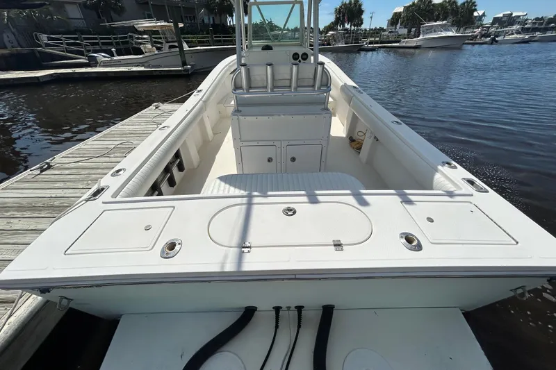 Slide: The Image of 2005 Regulator 26 Forward Seating boat docked at marina, showcasing spacious deck layout. - 4