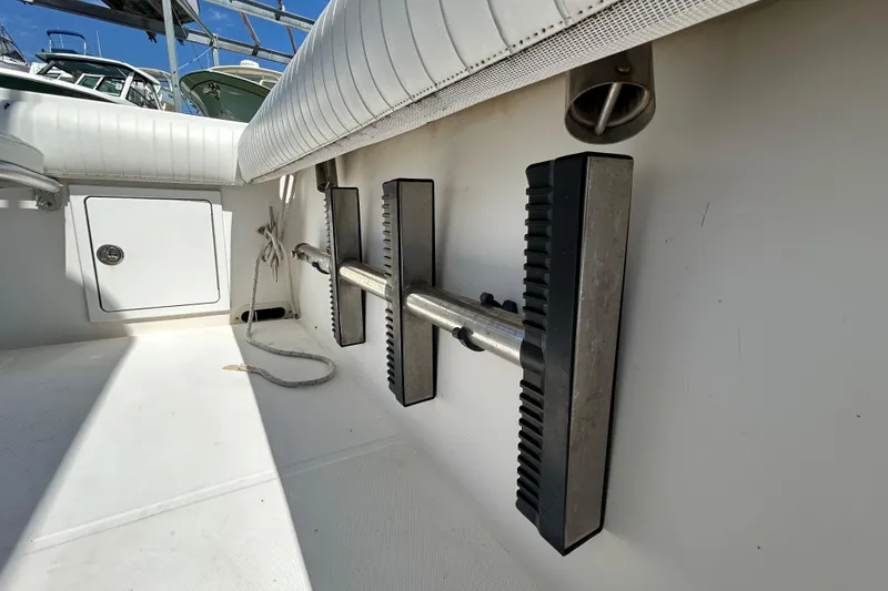 Slide: The Image of 2005 Regulator 26 Forward Seating boat interior with rod holders and storage compartment. - 40