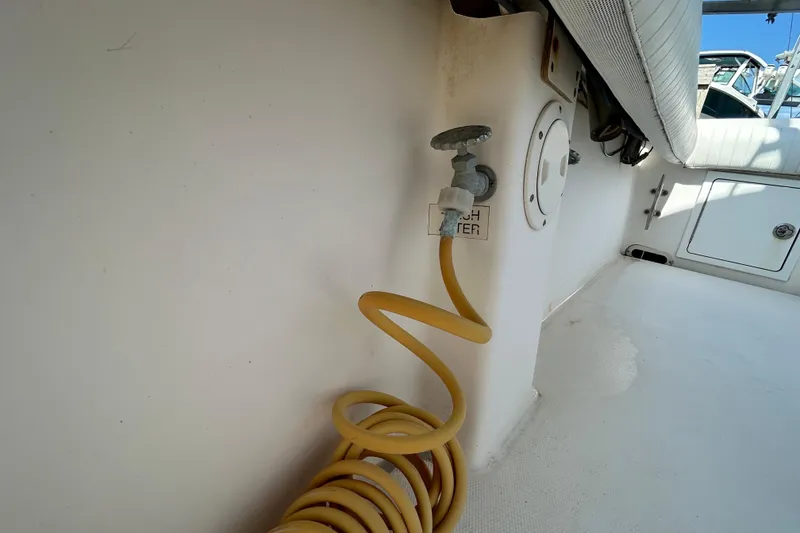 Slide: The Image of 2005 Regulator 26 Forward Seating boat with coiled yellow hose and fresh water tap. - 41