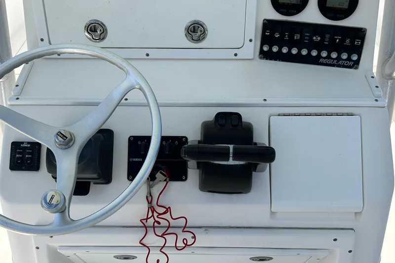Slide: The Image of 2005 Regulator 26 Forward Seating boat dashboard with steering wheel and controls. - 42