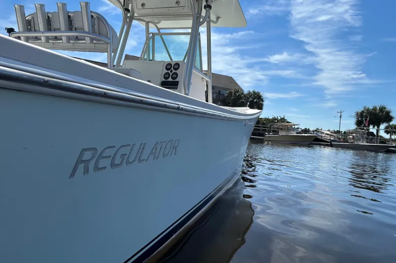 Slide: The Image of 2005 Regulator 26 Forward Seating boat on calm water under blue sky. - 43