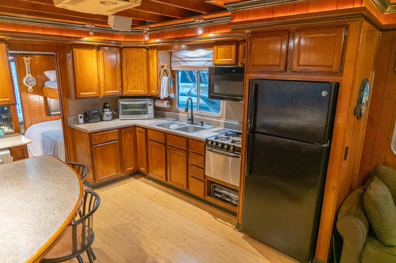 Slide: The Image of 1984 Sumerset 60 X 14 houseboat kitchen with wooden cabinets and modern appliances. - 16