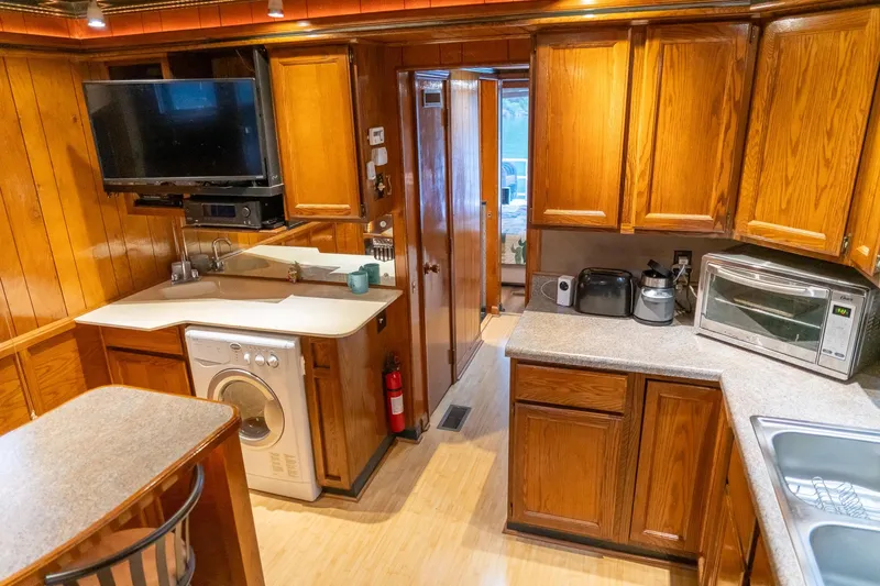 Slide: The Image of 1984 Sumerset 60 X 14 houseboat kitchen with wooden cabinets and modern appliances. - 22