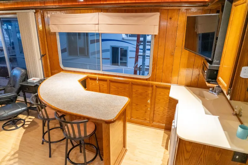 Slide: The Image of Interior of 1984 Sumerset 60 X 14 houseboat with wood paneling and bar area. - 23