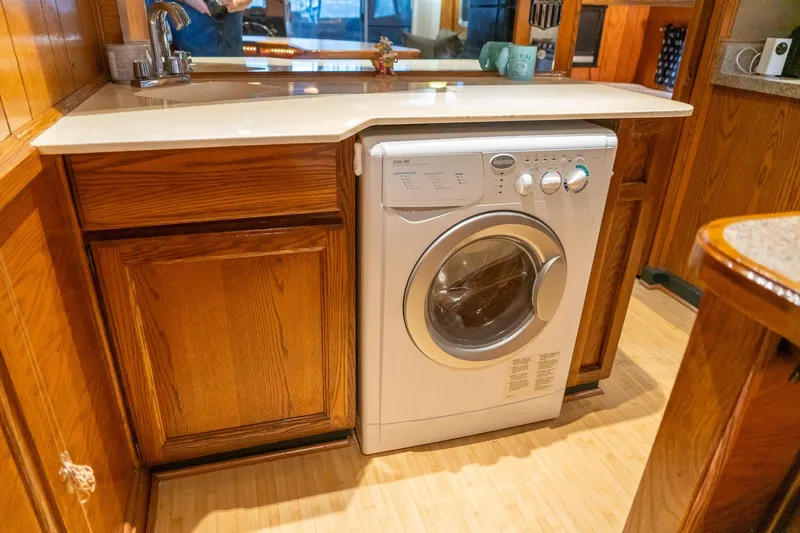 Slide: The Image of 1984 Sumerset houseboat kitchen with wooden cabinets and built-in washing machine. - 25