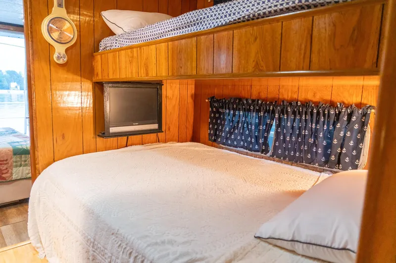 Slide: The Image of Cozy bedroom in 1984 Sumerset 60 X 14 houseboat with wood paneling and nautical decor. - 28