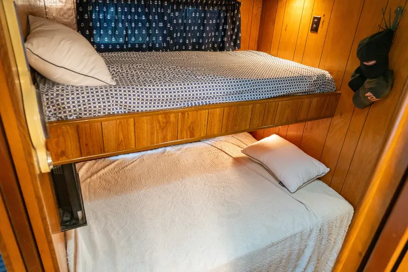 Slide: The Image of Bunk beds in 1984 Sumerset 60 X 14 houseboat with wood paneling and nautical curtains. - 29