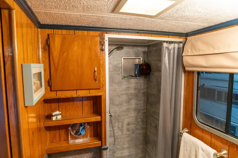 Slide: The Image of 1984 Sumerset houseboat bathroom with wooden cabinets, shower, and window. - 31