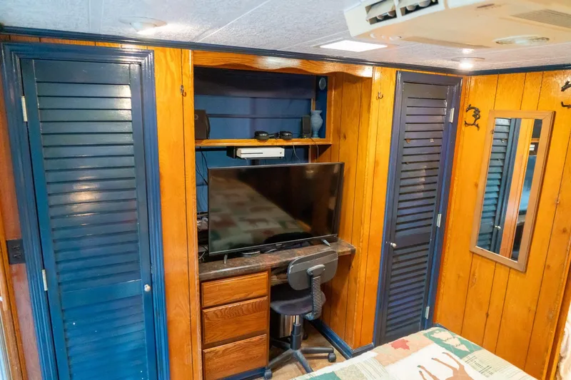 Slide: The Image of 1984 Sumerset 60 X 14 houseboat interior with wood paneling, TV, and storage cabinets. - 37