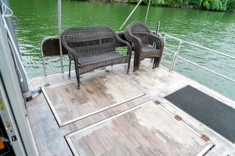 Slide: The Image of 1984 Sumerset 60 X 14 houseboat deck with wicker chairs by the water. - 39