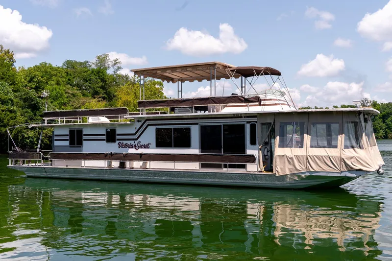 Slide: The Image of 1984 Sumerset 60 X 14 houseboat on a serene lake with lush greenery. - 4