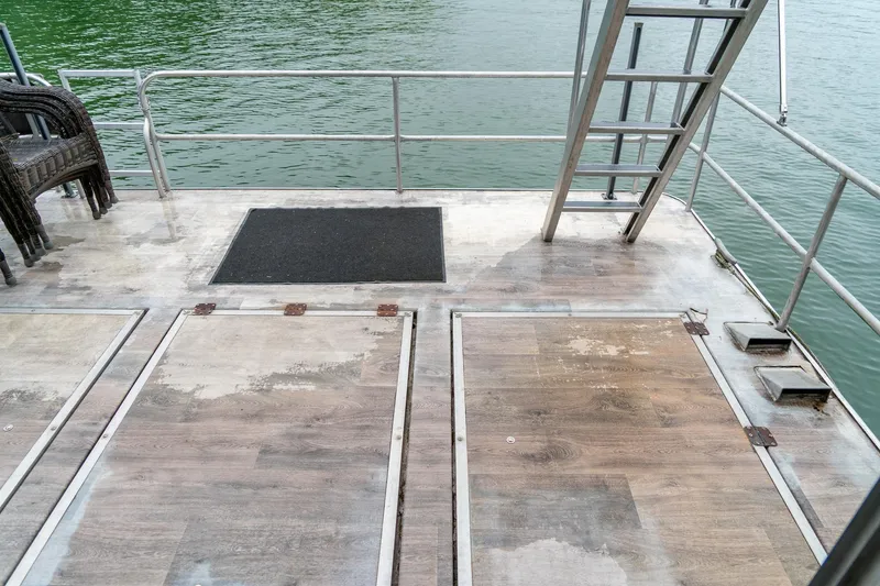 Slide: The Image of 1984 Sumerset 60 X 14 houseboat deck with railing and ladder by the water. - 40