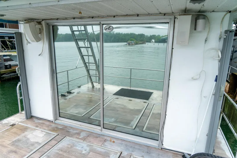 Slide: The Image of 1984 Sumerset 60 X 14 houseboat with glass doors overlooking serene lake view. - 41