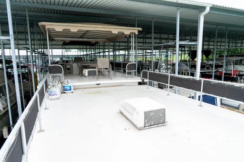 Slide: The Image of 1984 Sumerset 60 X 14 houseboat upper deck with seating and canopy in marina. - 43