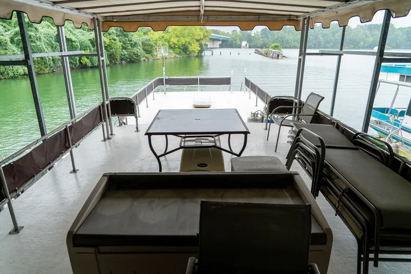 Slide: The Image of 1984 Sumerset 60 X 14 houseboat deck with chairs and table, overlooking serene water. - 47