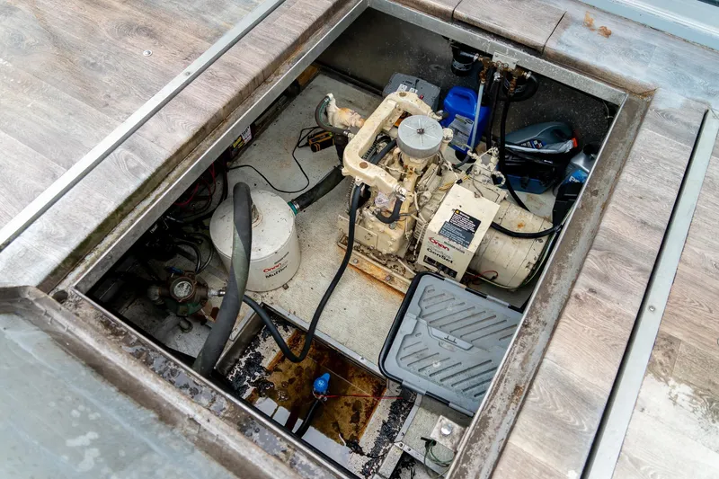 Slide: The Image of Engine compartment of a 1984 Sumerset 60 X 14 houseboat, showing mechanical components. - 50