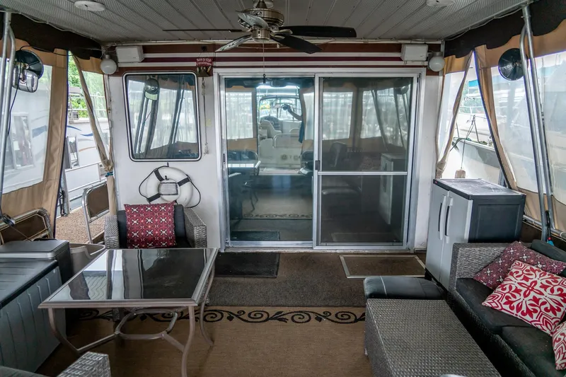Slide: The Image of 1984 Sumerset 60 X 14 houseboat interior with cozy seating and glass doors. - 8