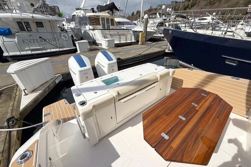 Slide: The Image of 2026 Tiara Yachts 43 LE at marina, featuring dual Mercury engines and wooden deck table. - 19