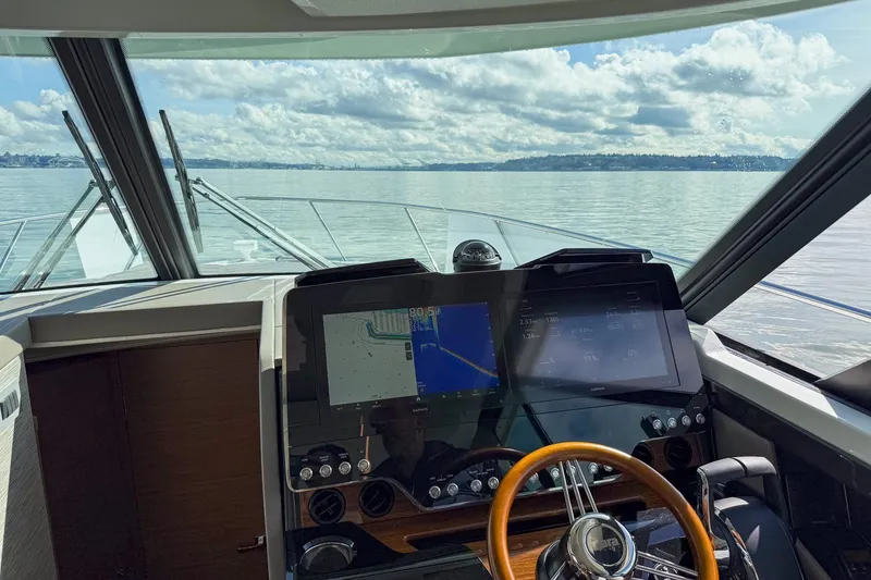 Slide: The Image of Cockpit view of 2026 Tiara Yachts 43 LE, featuring navigation screens and steering wheel. - 23