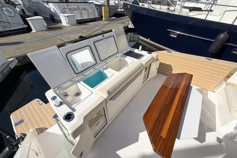 Slide: The Image of 2026 Tiara Yachts 43 LE deck with seating and storage at marina. - 30