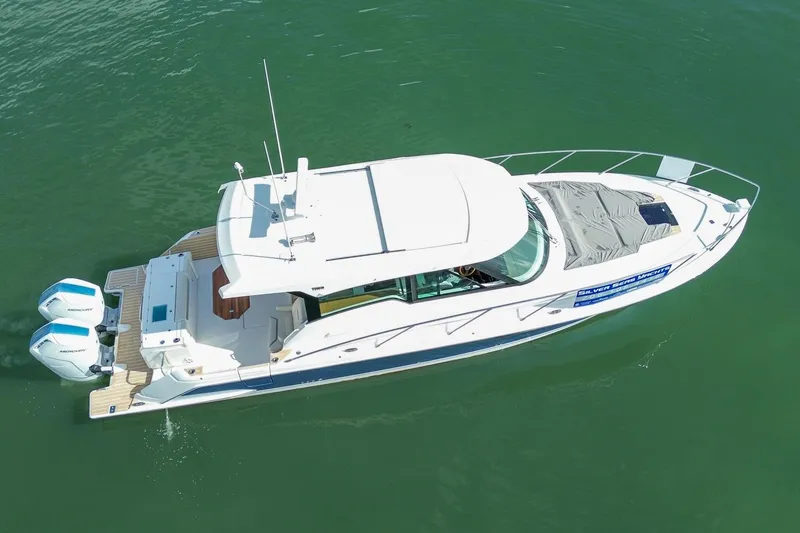 Slide: The Image of 2026 Tiara Yachts 43 LE cruising on calm green waters, aerial view. - 4