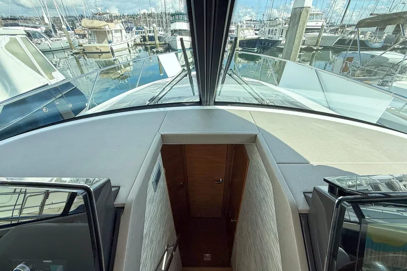 Slide: The Image of Interior view of 2026 Tiara Yachts 43 LE, showcasing cabin entrance and marina backdrop. - 46