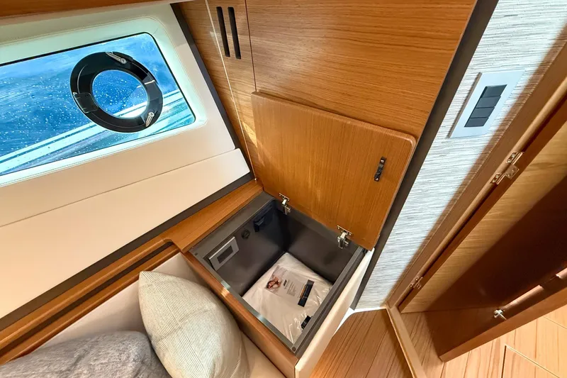 Slide: The Image of 2026 Tiara Yachts 43 LE interior with wooden cabinetry and porthole window. - 58