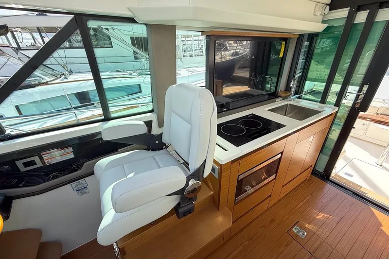 Slide: The Image of Interior of 2026 Tiara Yachts 43 LE featuring helm seat and compact kitchen area. - 61