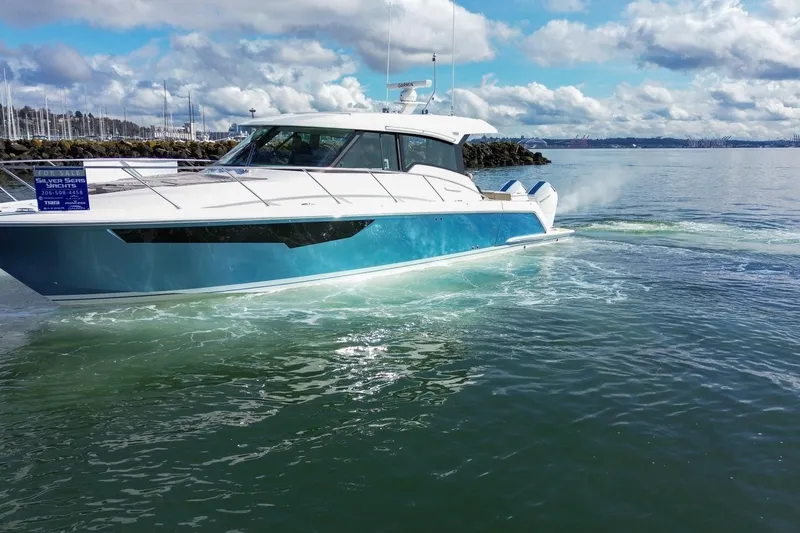 Slide: The Image of 2026 Tiara Yachts 43 LE cruising on a sunny day near a marina. - 9