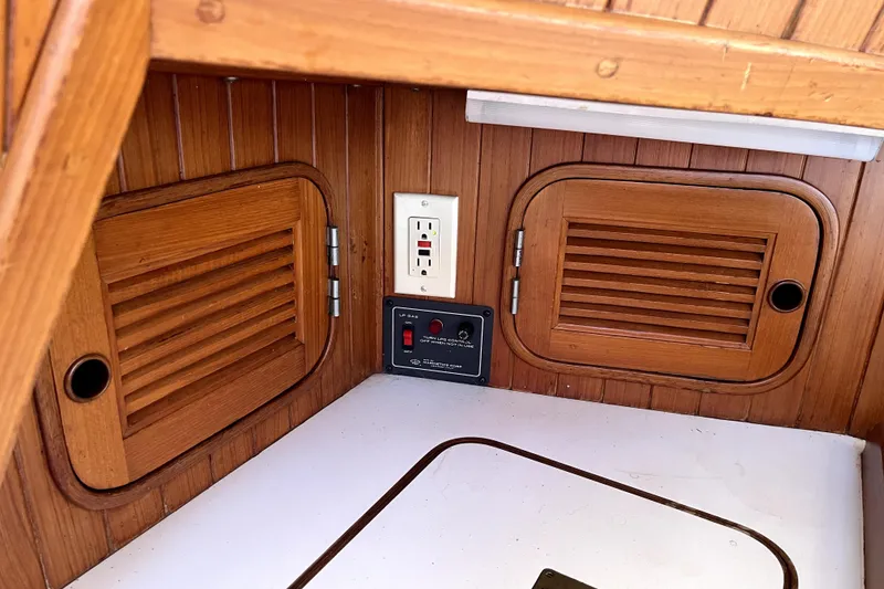 Slide: The Image of Wooden interior of 1985 Baba 40 Pilot House with electrical outlet and control panel. - 31