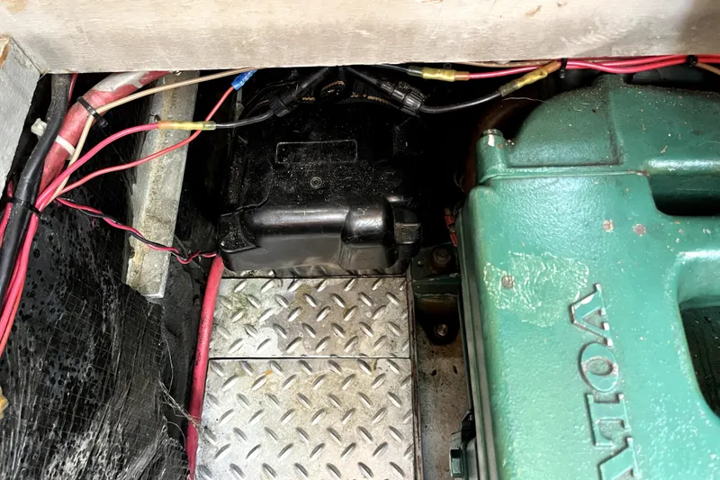 Slide: The Image of Engine compartment of a 1985 Baba 40 Pilot House with visible wiring and Volvo engine. - 41