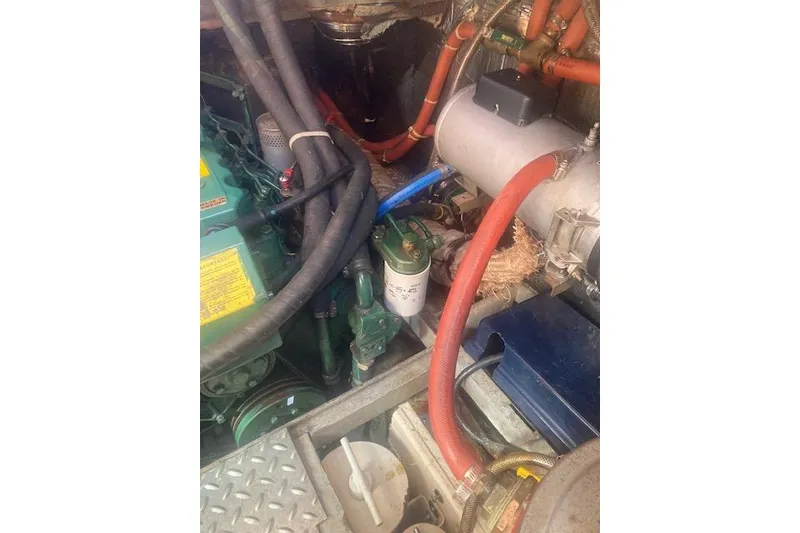 Slide: The Image of Engine compartment of a 1985 Baba 40 Pilot House with visible hoses and components. - 44