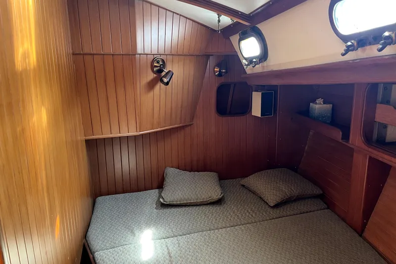 Slide: The Image of Cozy cabin interior of 1985 Baba 40 Pilot House with wooden paneling and bedding. - 51