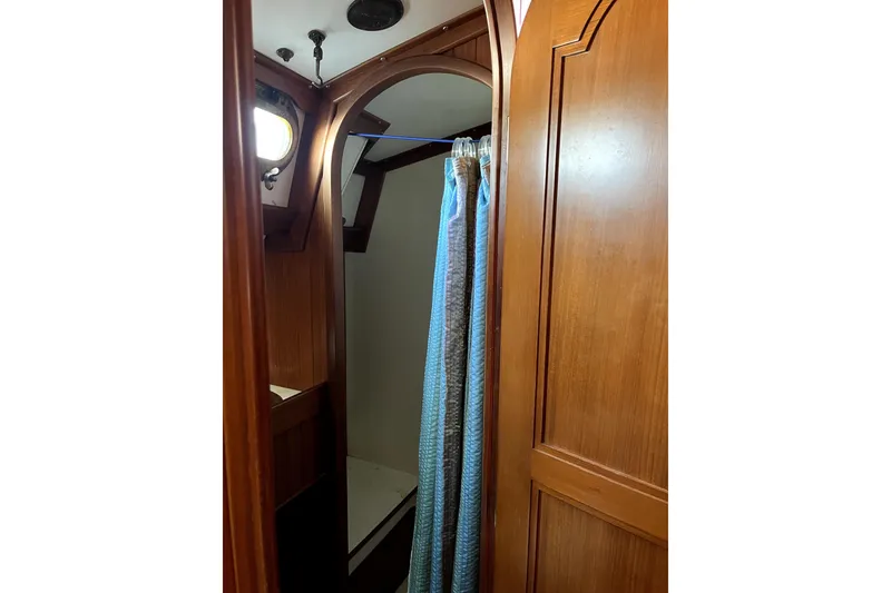 Slide: The Image of Interior of 1985 Baba 40 Pilot House with wooden paneling and shower curtain. - 60