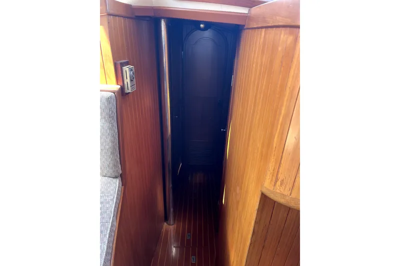 Slide: The Image of Interior hallway of 1985 Baba 40 Pilot House with wooden paneling and door. - 61